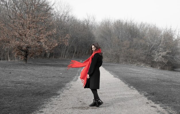 Photo une femme debout sur la route au milieu des arbres