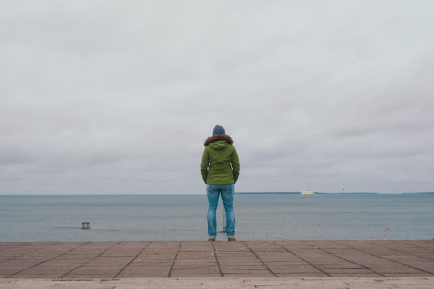 Femme debout seule sur la jetée regardant la mer lors d'une froide journée d'hiver à Tallinn Estonie