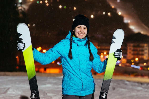 Femme debout avec ski au sommet de la colline enneigée