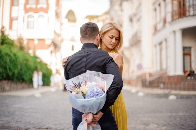 Femme debout avec son petit ami et bouquet de roses et d'hydrange