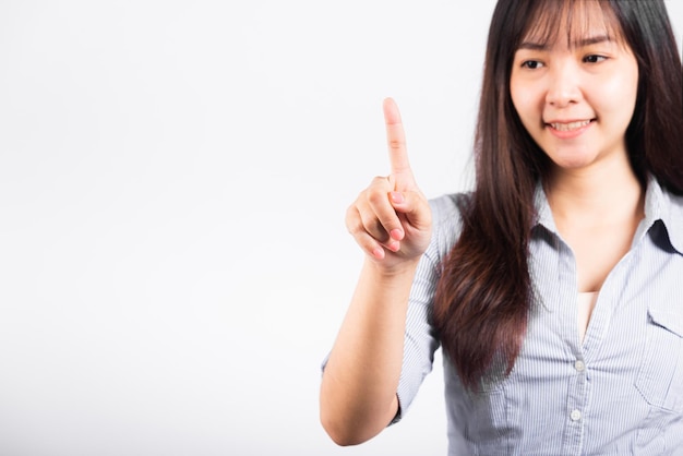 Femme debout son sourire confiance en touchant un écran imaginaire avec son doigt