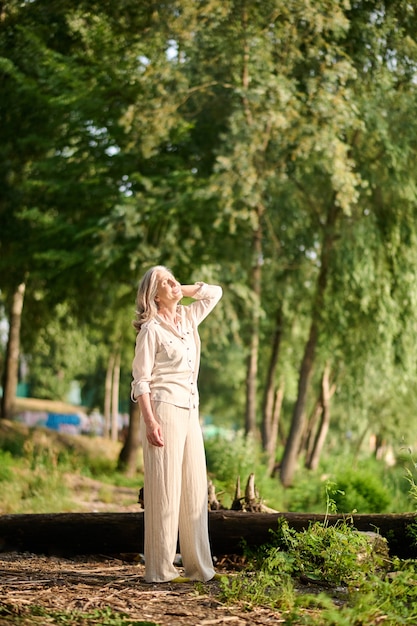 Femme debout sous les rayons du soleil dans la nature