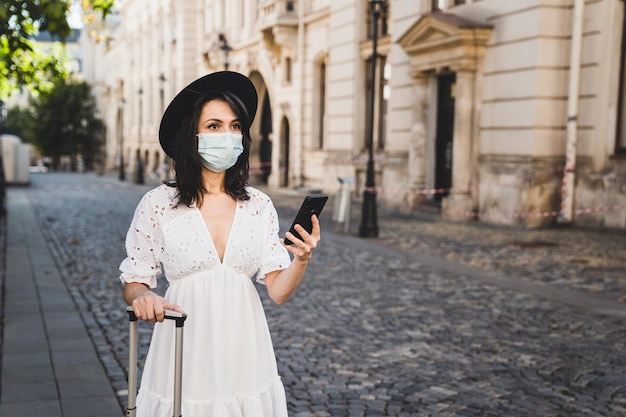 Femme debout sur un téléphone portable en ville