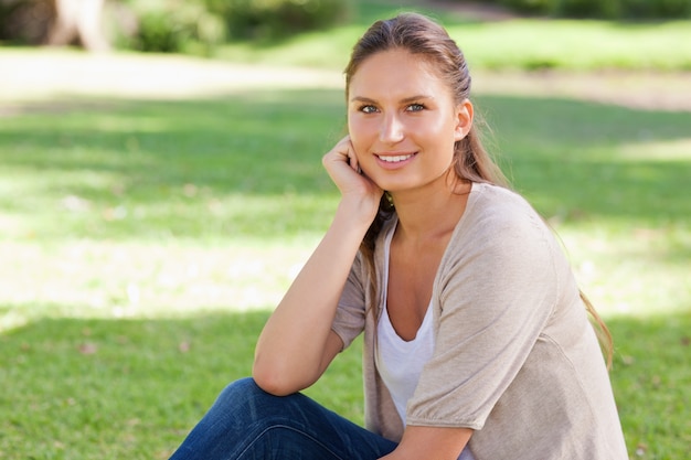 Femme décontractée assise sur la pelouse