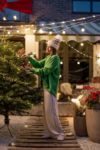 Femme décorant l'arbre de Noël à l'arrière-cour