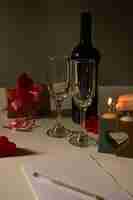 Photo une femme décorant une table avec du vin, des voiles et des cadeaux pour le jour de saint-valentin des amoureux.