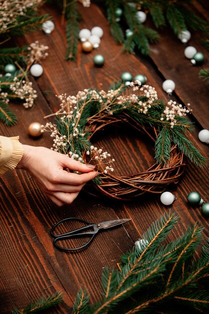 Photo une femme décore une couronne pour noël