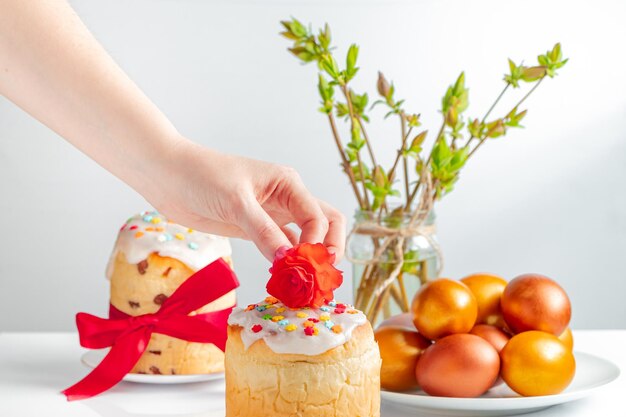 Femme décore un gâteau de Pâques avec fleur Symbole de bonne fête chrétienne