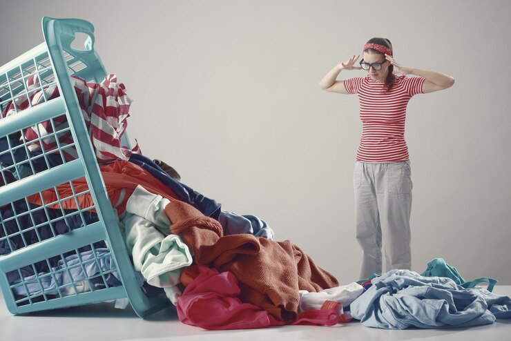 Photo une femme déçue et en colère regardant des vêtements sales.