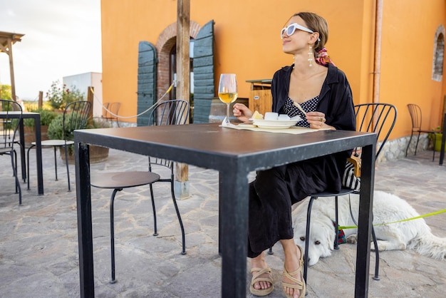 Femme dégustant du fromage et du vin dans un magasin de ferme local en italie