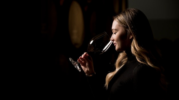 Femme dégustant du vin en cave