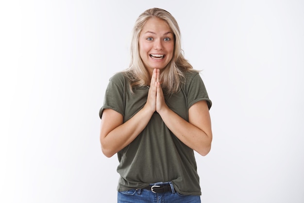 Femme demandant à un ami peu de faveur se tenant la main dans la prière en appuyant les paumes ensemble sur le corps souriant avec un sourire d'ange suppliant