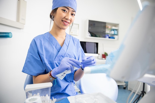 Femme dentiste à la clinique dentaire lors de la préparation des outils de travail