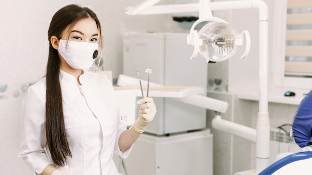 Femme dentiste dans un masque médical