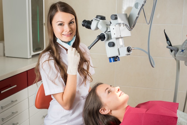 Femme dentiste dans son bureau traitant une patiente