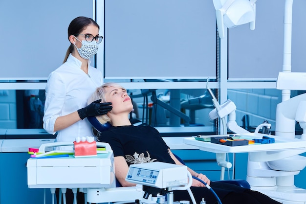 Femme dentiste examinant une patiente à la clinique