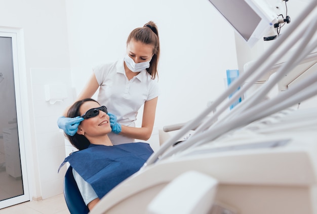 Femme dentiste et un patient au cabinet dentaire