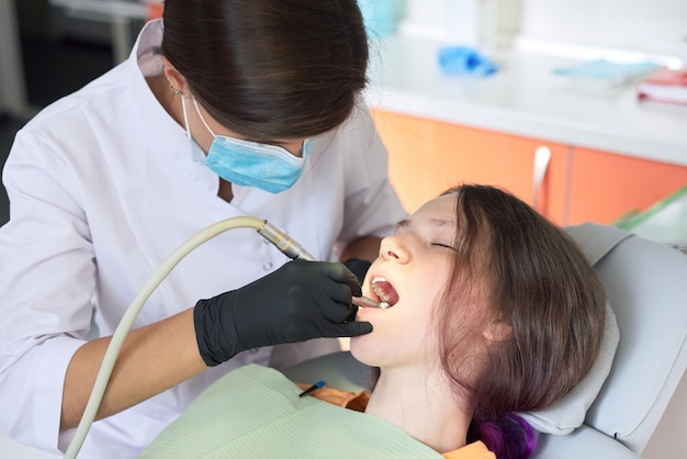 Femme dentiste traitant une fille