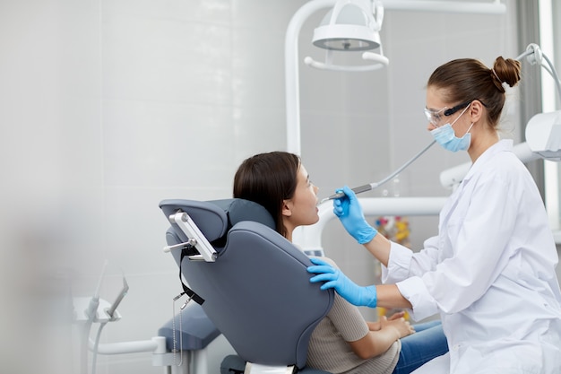 Femme dentiste travaillant avec l'enfant