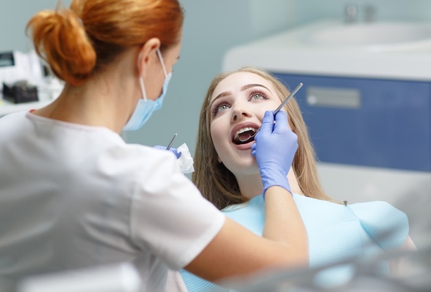 Femme dentiste vérifiant les dents du patient