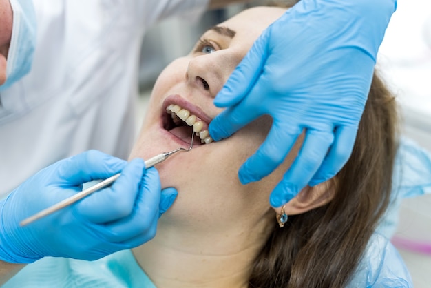 Femme en dentisterie démontrant les dents au médecin