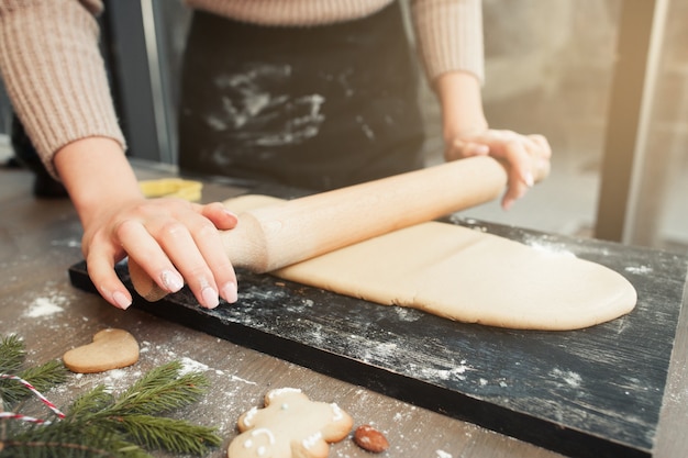 Femme déployant la pâte à la cuisine