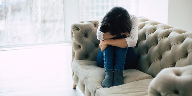 Femme déprimée avec une coupe courte qui pleure en touchant son visage. Fille qui crie les yeux fermés à cause de sa maladie mentale.