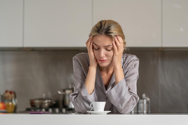 Femme déprimée ennuyée dans la cuisine le matin