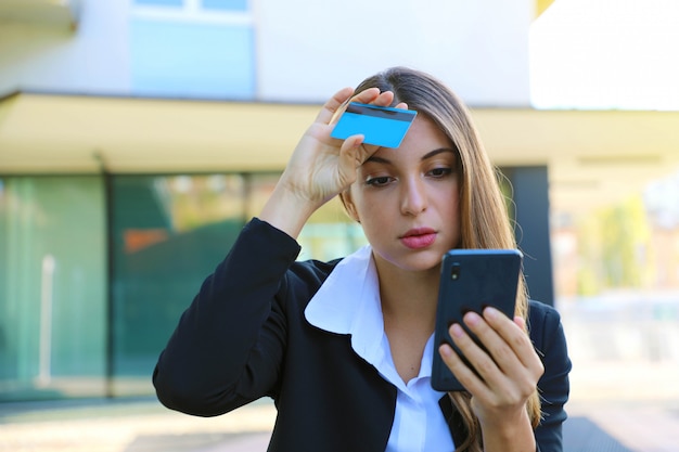 Photo femme désespérée à la recherche de téléphone son relevé de carte de crédit a souligné