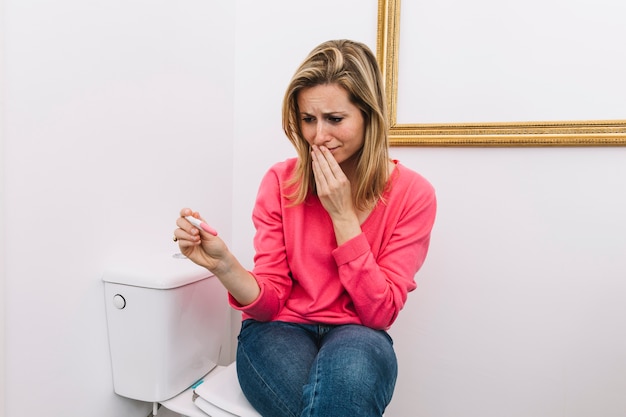 Photo femme désespérée avec un test de grossesse