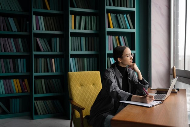 Femme designer avec lunettes rapport d'entreprise travaillant au bureau à l'aide d'un ordinateur portable éducation en ligne des étudiants