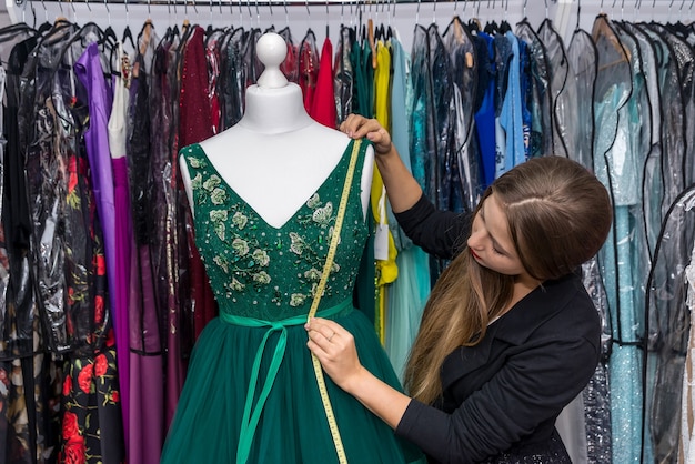 Femme designer travaillant avec une robe et un ruban à mesurer