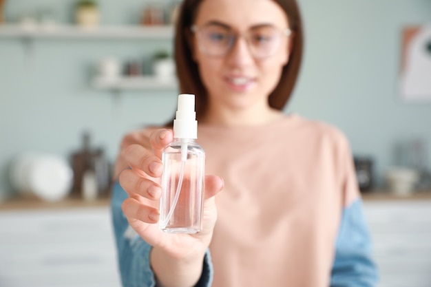 Femme avec un désinfectant à la maison