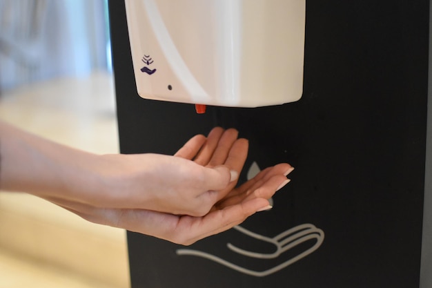 la femme désinfecte les mains la personne se nettoie les mains avec une solution hygiénique