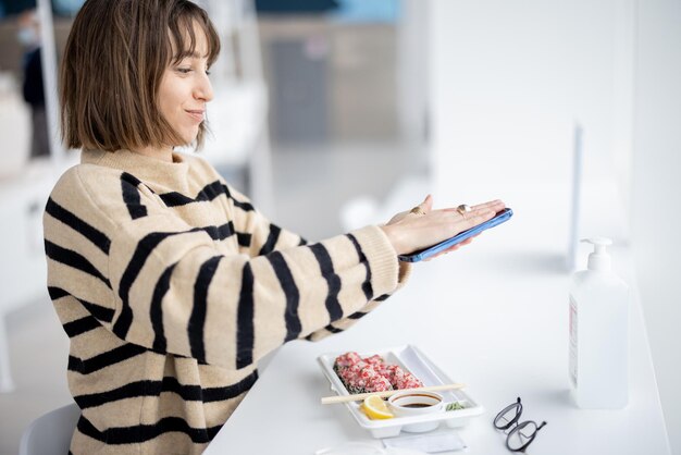 Une femme désinfecte le téléphone avec un désinfectant au restaurant