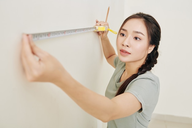 Femme dessinant des marques sur le mur