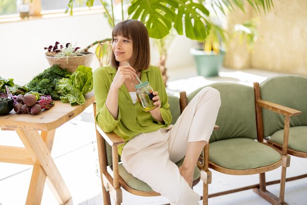 Femme détendue avec des aliments sains dans la chambre avec des plantes