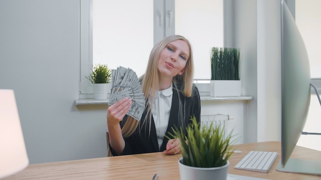 Femme détendue avec de l'argent au bureau