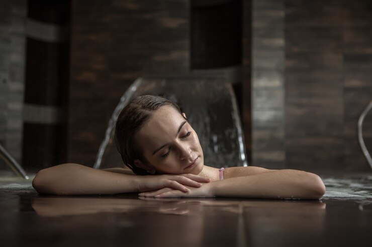 Femme détendue au repos dans la piscine spa de luxe