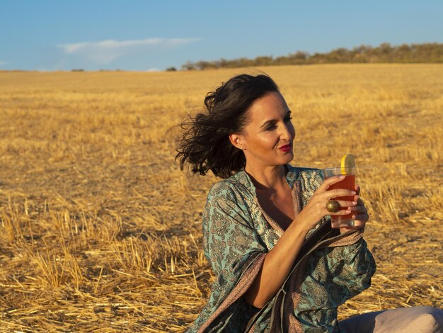 Femme détendue avec boisson en milieu rural