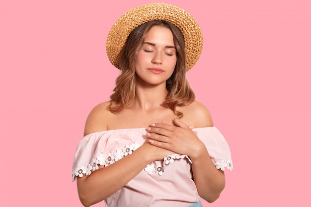 Femme détendue calme garde les mains sur le cœur