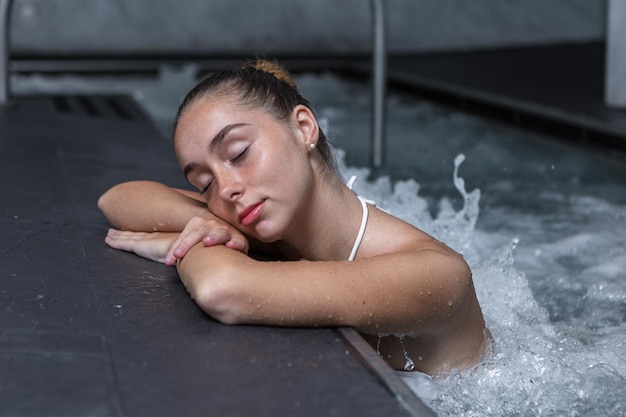 Une femme détendue pendant une séance d'hydrothérapie dans la piscine