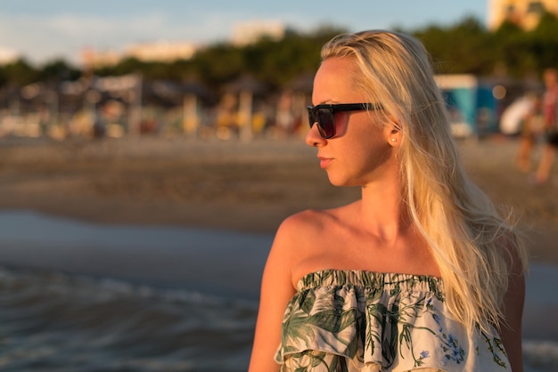 Femme détendue en robe profitant de la plage tropicale et des vacances d'été des Caraïbes Fit Brunette bronzée profitant d'une promenade dans la mer