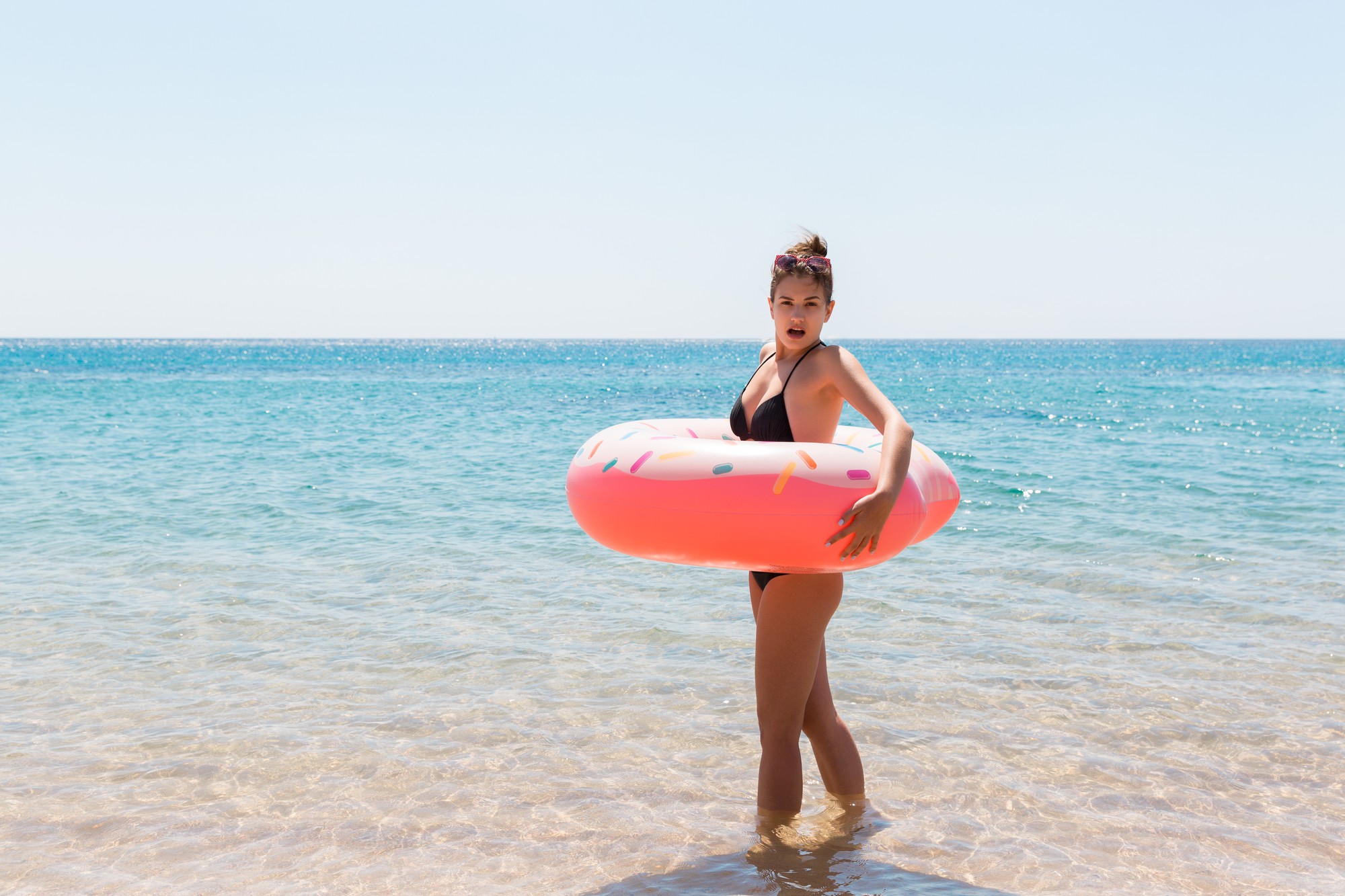 Femme détente avec anneau gonflable sur la plage. fille choquée ou surprise dans la mer froide. Vacances d'été et concept de vacances.