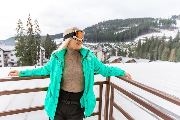 Femme détente en terrasse sur la montagne, neige sur les collines.