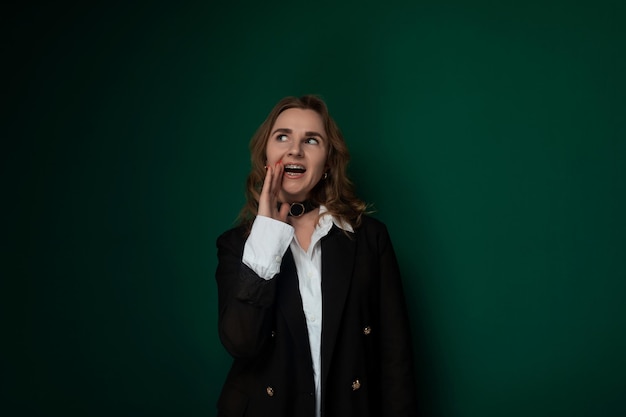 Une femme devant un mur vert.