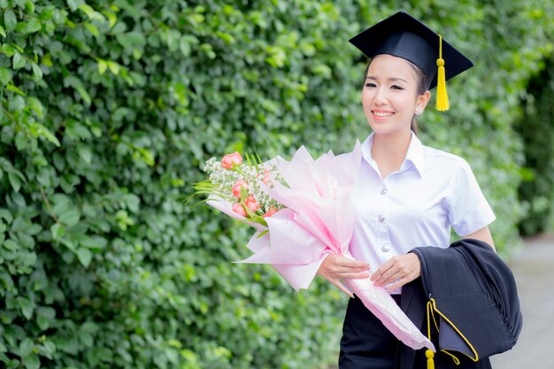 femme diplômée tenant un bouquet