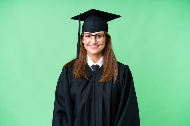 Femme diplômée de l'université d'âge moyen sur fond isolé avec des lunettes et heureux