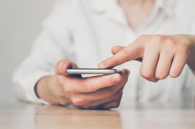 Femme dirige une entreprise via un smartphone tout en étant assis dans un bureau