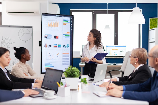 Femme Dirigeante Entraîneure Présentatrice Donnant Une Présentation Financière Dans Une Salle De Réunion De Bureau Moderne Pour Les Employés De L'entreprise